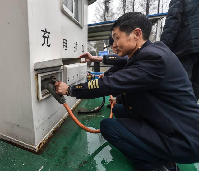 1月18日，工作人員在為純電動貨運船插上充電線。該電動貨運船一次充電可以行駛200至300公里，充電時間大約6至8小時。