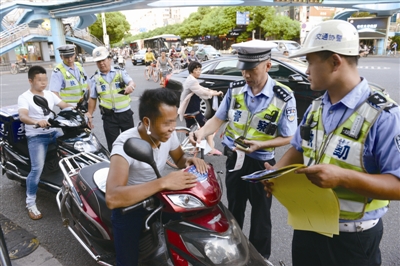 昨天下午，交警在市區(qū)城開天橋下管理電動車。蔣文廣 攝